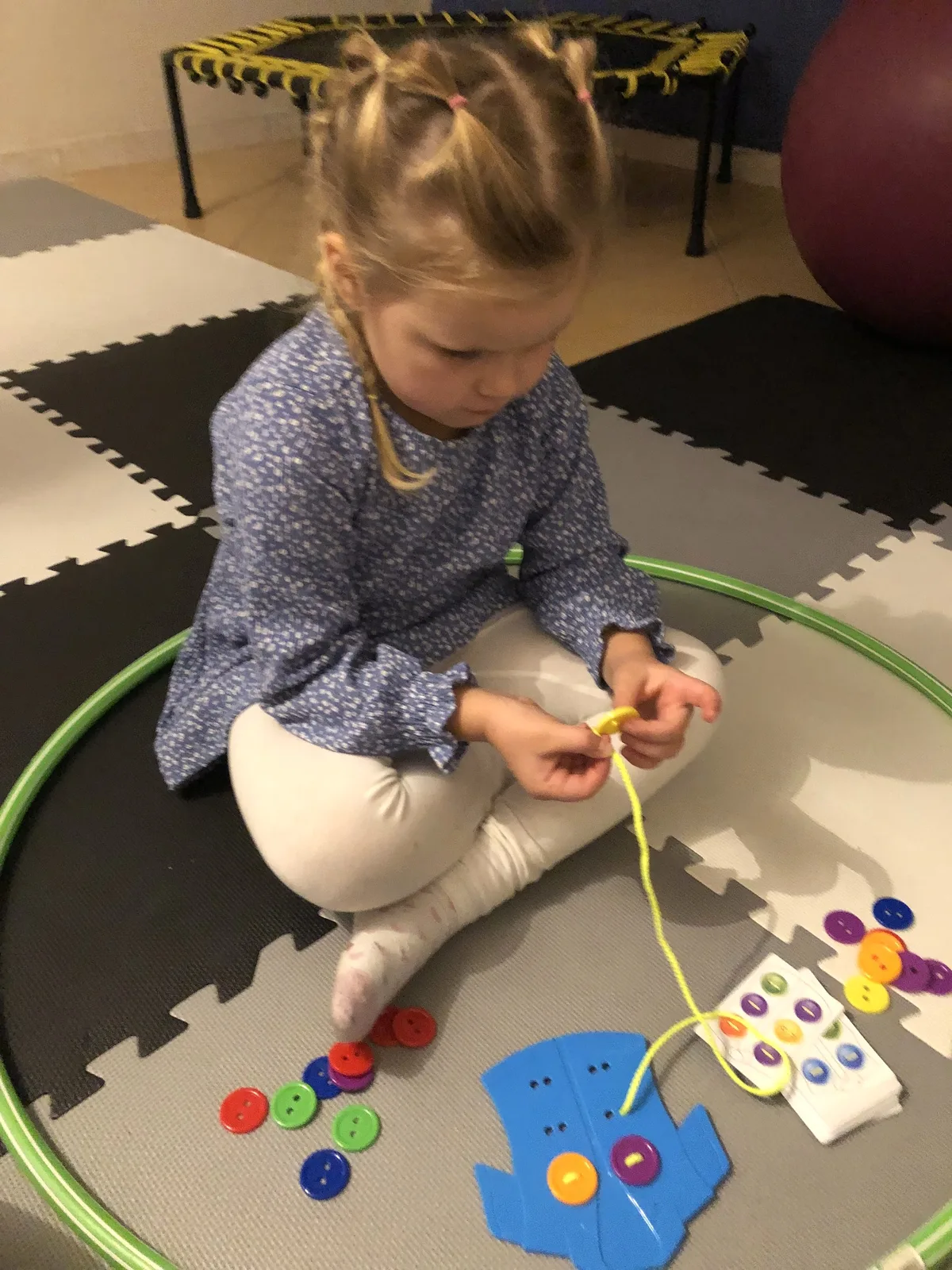 Dziecko nawleka guziki podczas zadania manualnego
